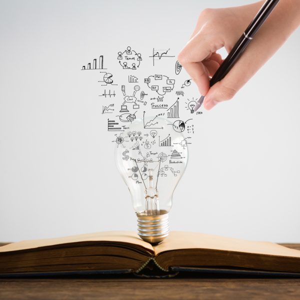 Book and light bulb with hand drawing graph Book and light bulb with hand drawing graph
